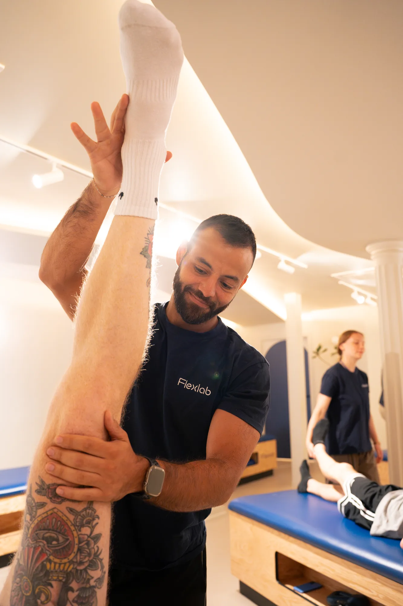 Un flexologue Flexlab étire la jambe d'un membre allongé sur la table