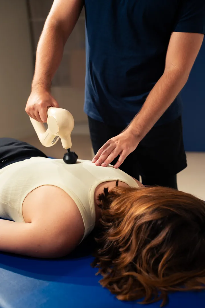 Massage par percussion sur le dos d'une cliente, en fin de protocole
